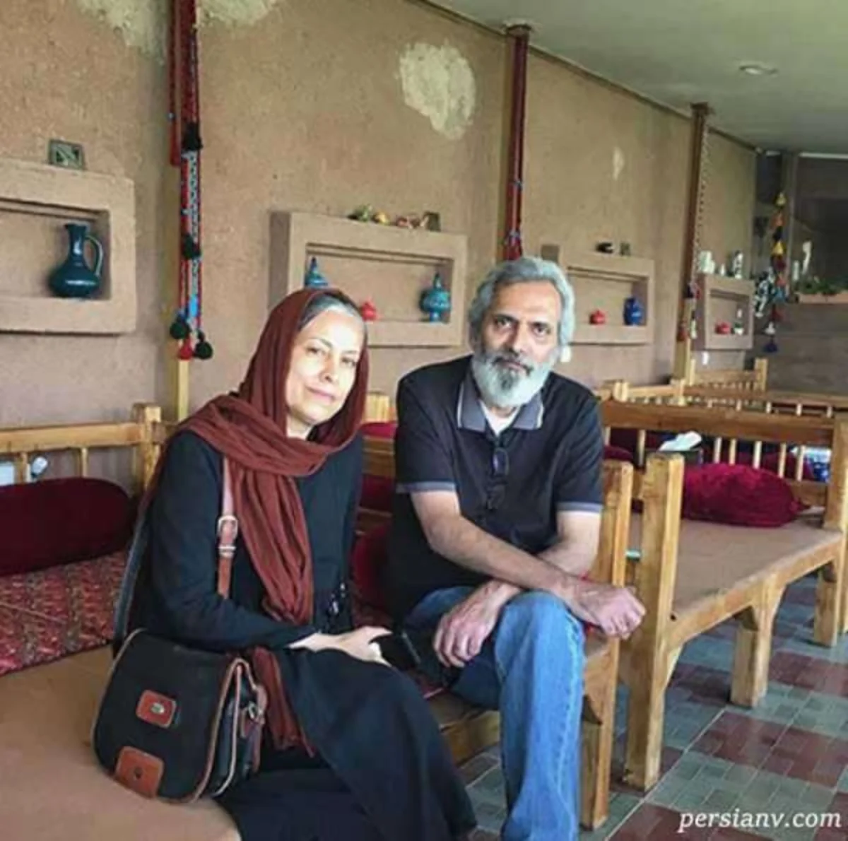 سهیلا رضوی با روسری زرشکی در کنار فرخ نعمتی روی نیمکت چوبی
