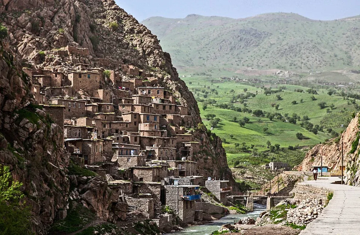 نمای روستای سنگی پالنگان روی دامنه کوه و چشم‌انداز دره سبز در کنار مسیر دسترسی